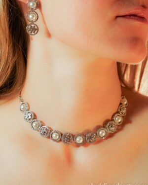 Woman wearing pearl and diamond jewelry set.