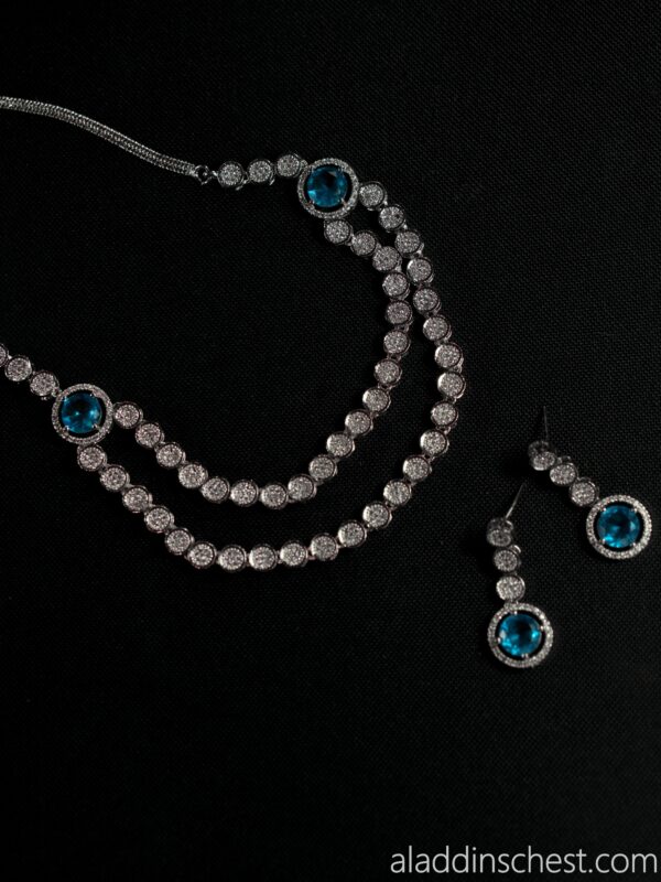 Elegant blue gemstone jewelry set on black background.