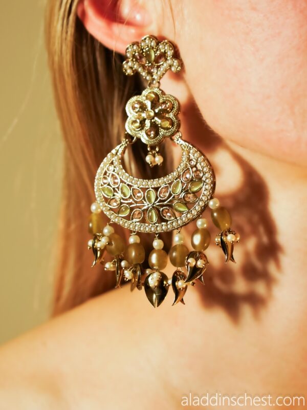 Intricate gold earring with gemstones and beads.