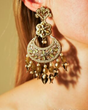Intricate gold earring with gemstones and beads.