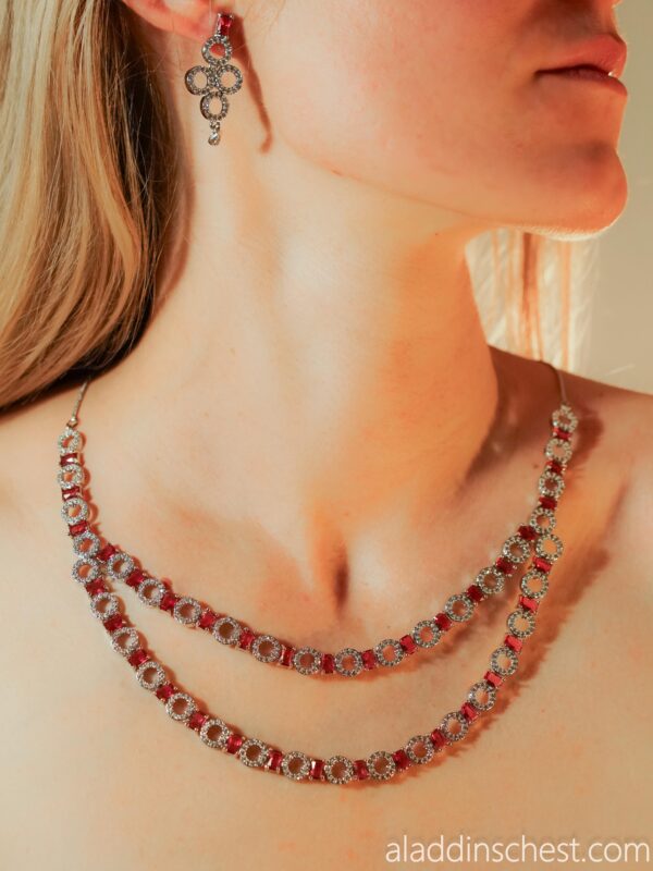 Elegant necklace and earrings with red gems.