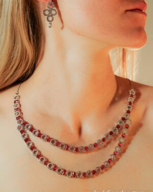 Elegant necklace and earrings with red gems.