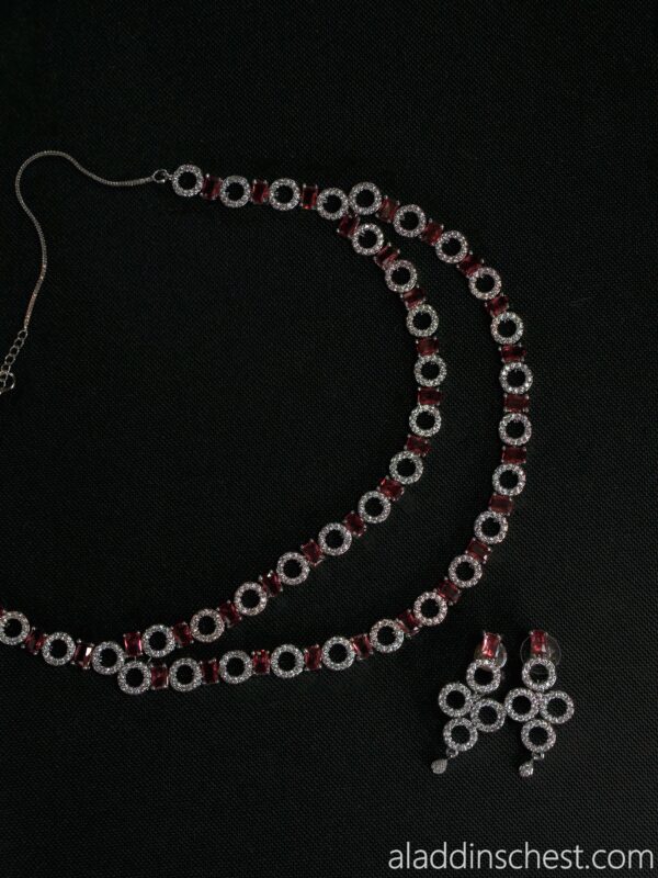Elegant ruby and diamond jewelry set on black background.