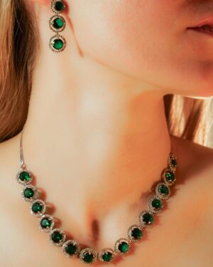 Woman wearing emerald necklace and earrings