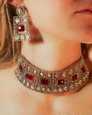 Woman wearing elegant jewelry with red gemstones.
