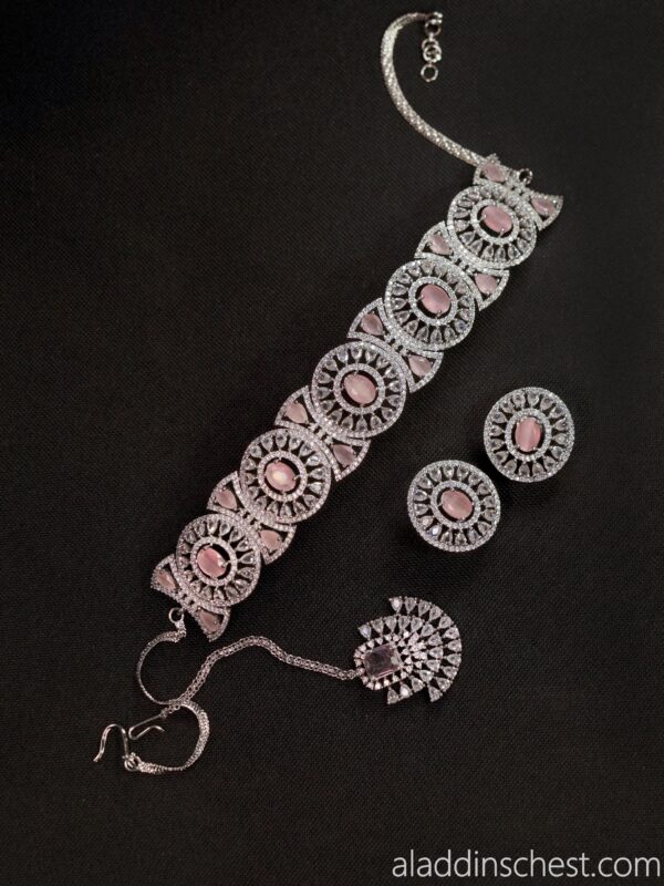 Elegant pink and silver jewelry set on black.