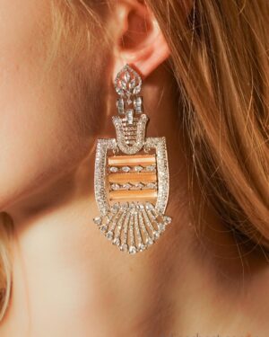 Close-up of ornate gold earring with crystals.