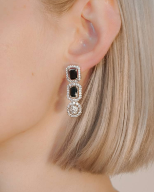 Woman wearing elegant black gemstone earrings.