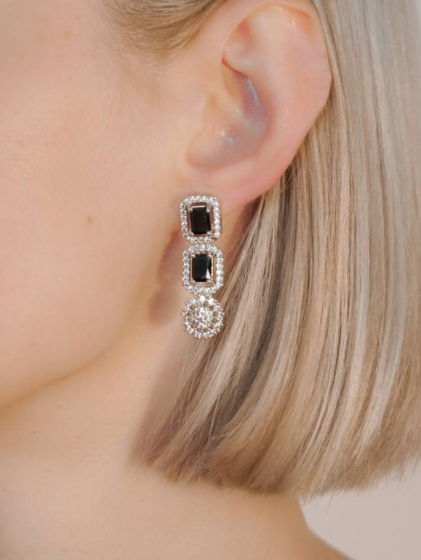 Woman wearing elegant black gemstone earrings.