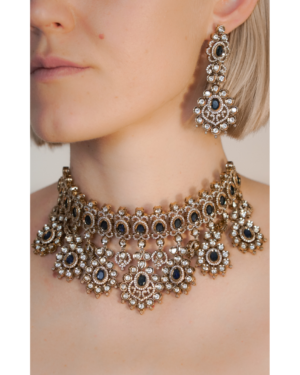 Woman wearing ornate gold and gemstone jewelry set.