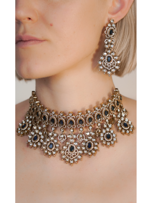 Woman wearing ornate gold and gemstone jewelry set.