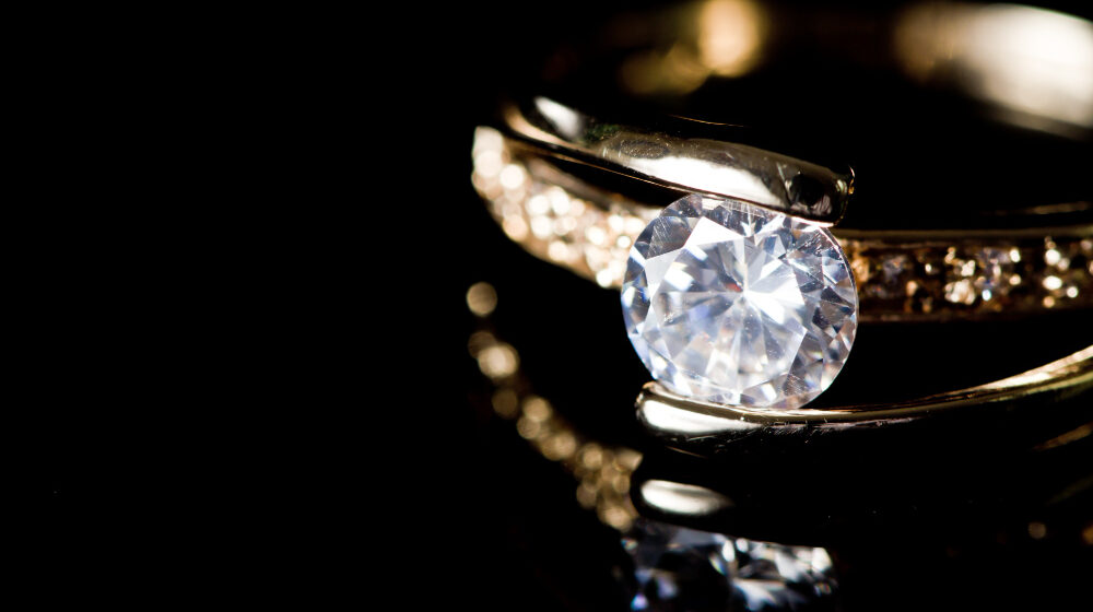 Close-up of diamond ring on black background.
