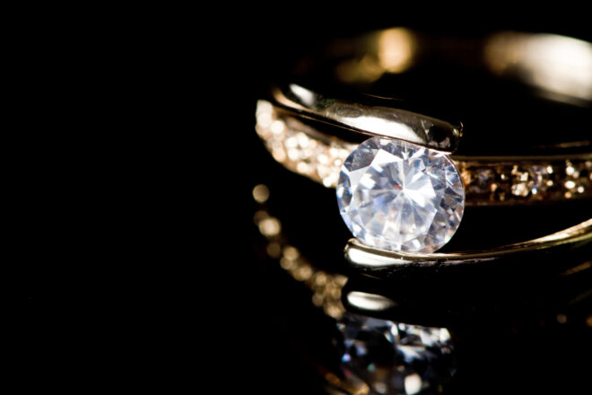 Close-up of diamond ring on black background.