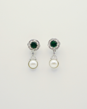 Elegant pearl and emerald earrings on display