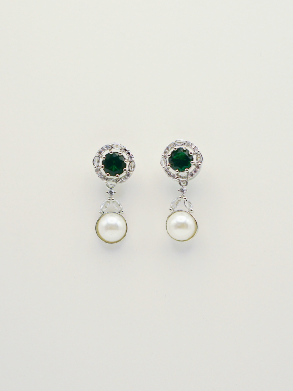 Elegant pearl and emerald earrings on display