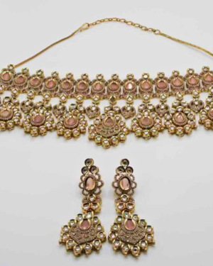 Gold choker necklace and earrings with gemstones.